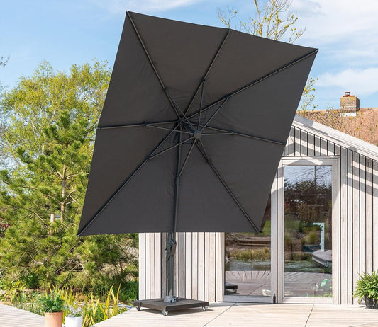 Cantilever parasol viewed from underneath showing sturdy frame and ribs, positioned on a wooden deck beside a contemporary garden room for stylish outdoor shade.