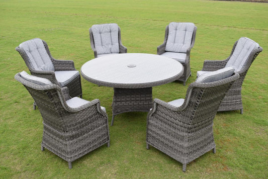 Outdoor rattan dining set featuring a round table with a glass top and six cushioned chairs. Ideal for garden gatherings, offering comfort and elegance on a green lawn.