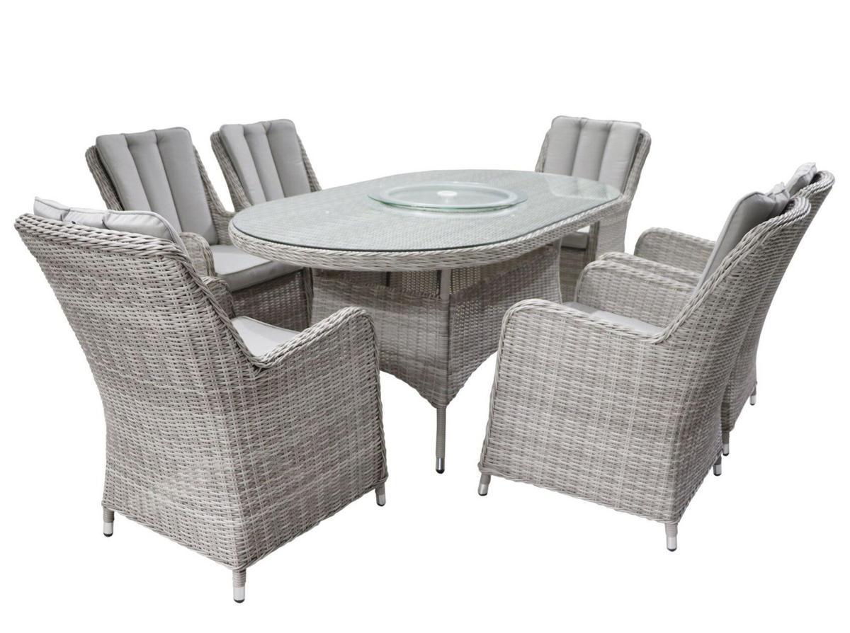 Grey wicker outdoor dining set featuring an oval glass-top table with a Lazy Susan and six cushioned chairs. Ideal for garden or patio gatherings.